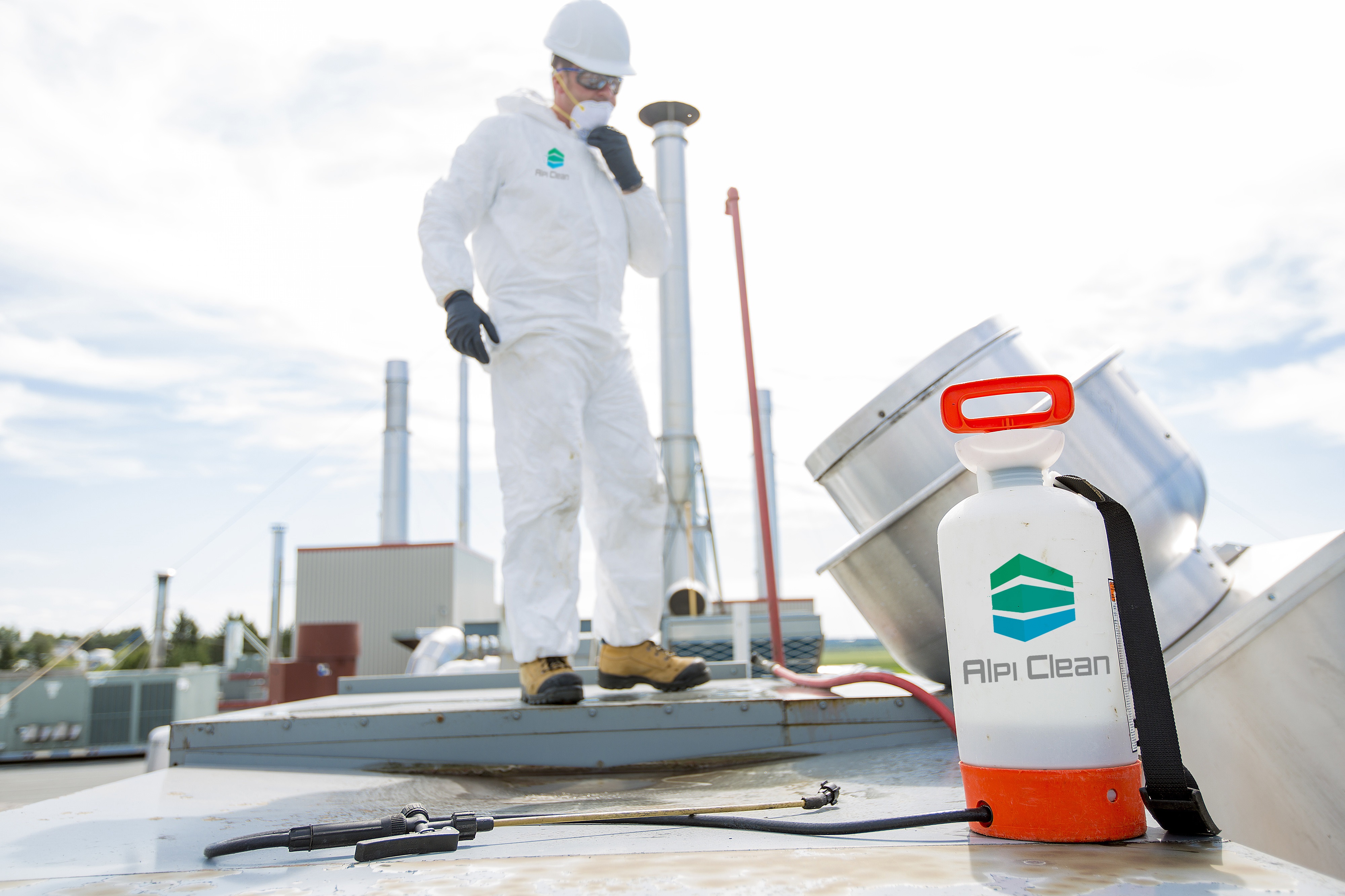 professional in protective uniform, mask, gloves in the roof for cleaning